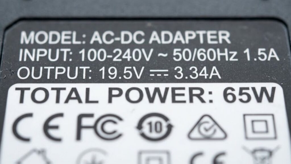 Close up of an AC-DC adapter specification label showing total power in watts used to calculate 12V power needs.